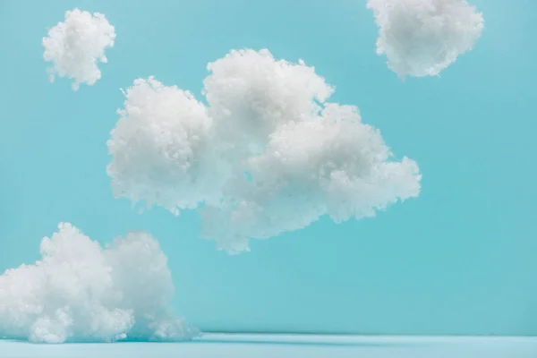 Nuages duveteux blancs en laine de coton isolé sur bleu — Photo de stock