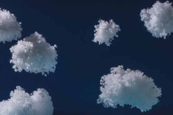 Nuages duveteux blancs en laine de coton isolé sur bleu foncé — Photo de stock