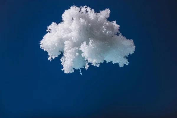 Nube esponjosa blanca hecha de lana de algodón aislada en azul oscuro - foto de stock