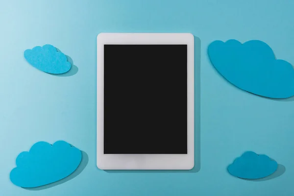 Vista superior de nuvens de papel vazias perto do tablet digital com tela em branco no azul — Fotografia de Stock