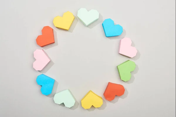 Верхний вид рамки цветных бумажных сердец на сером фоне — стоковое фото