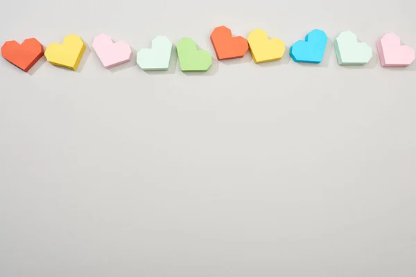 Вид зверху барвистих паперових сердець на сірому фоні з простором для копіювання — стокове фото