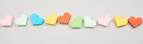 Top view of line from colored paper hearts on grey background, panoramic shot — Stock Photo