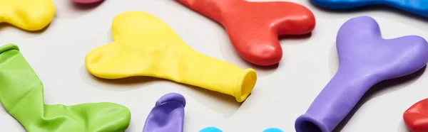 Panoramic shot of festive heart shaped balloons on grey background — Stock Photo