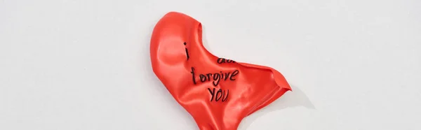 Top view of red balloon with i forgive you lettering on grey background, panoramic shot — Stock Photo