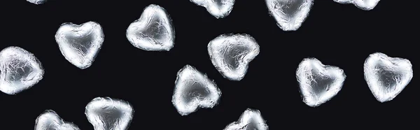 Top view of heart shaped candies in foil isolated on black, panoramic shot — Stock Photo