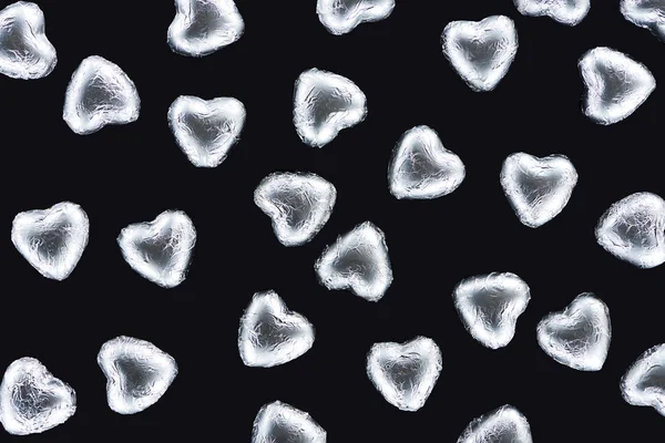 Top view of sweets in foil in heart shape isolated on black — Stock Photo