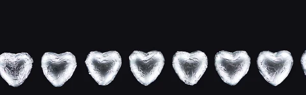 Vue du dessus des bonbons en forme de coeur isolés sur noir avec espace de copie, vue panoramique — Photo de stock