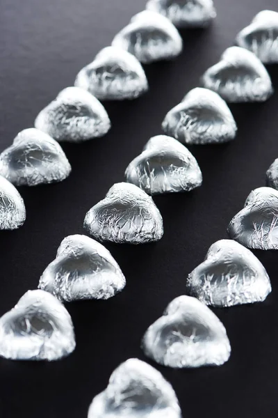 Concentration sélective de bonbons en forme de cœur sur fond noir — Photo de stock