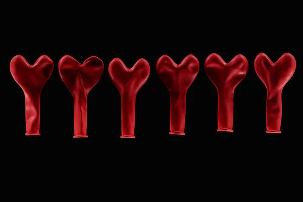 Vista superior de balões em forma de coração vermelho isolados em preto — Fotografia de Stock