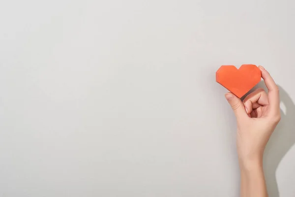 Top view of girl holding paper heart on grey background with copy space — Stock Photo