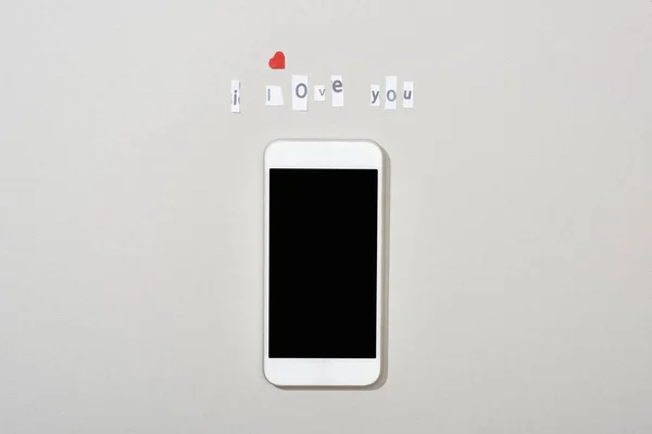Visão superior do smartphone com tela em branco e eu amo você lettering no fundo cinza — Fotografia de Stock