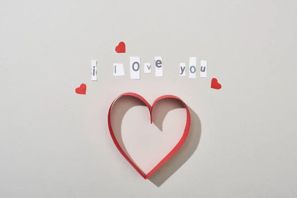 Top view of paper hearts with i love you lettering on grey background — Stock Photo