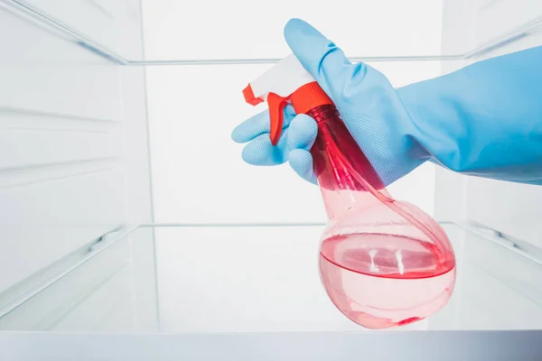 Cropped view of woman in rubber glove cleaning refrigerator with detergent spray isolated on white — Stock Photo