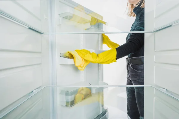 Vista recortada de la mujer limpieza nevera estante aislado en blanco - foto de stock