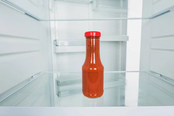 Flasche Tomatensauce im Kühlschrank mit offener Tür isoliert auf weiß — Stockfoto