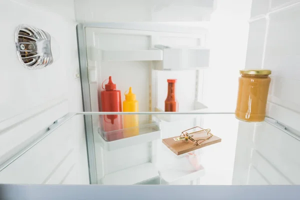 Селективный фокус мышеловки в холодильнике с открытой дверью, изолированной на белом — стоковое фото