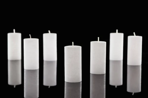 Selective focus of white candles with reflection isolated on black — Stock Photo