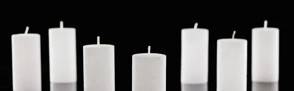 Fuoco selettivo di candele bianche isolate su colpo nero, panoramico — Foto stock