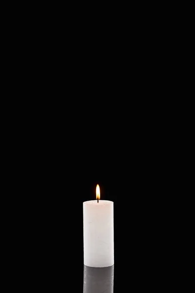 Burning white candle glowing isolated on black — Stock Photo