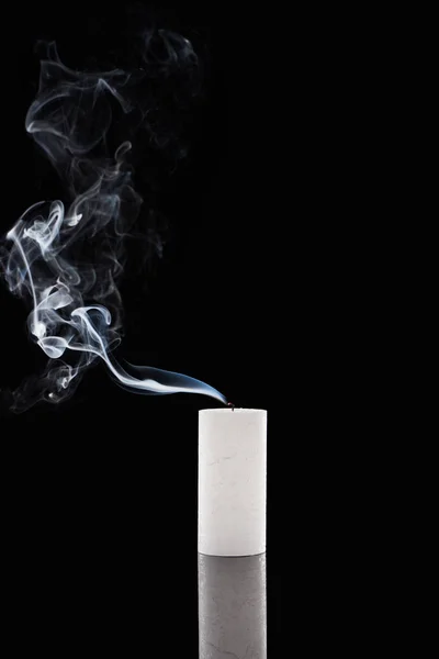 Extinct white candle with smoke on black background — Stock Photo