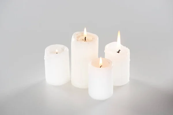 Bougies allumées sur fond blanc avec ombre — Photo de stock