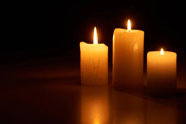 Velas encendidas que brillan en la oscuridad aisladas en negro - foto de stock