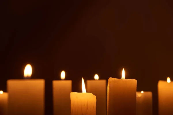 Selective focus of burning candles glowing in dark — Stock Photo