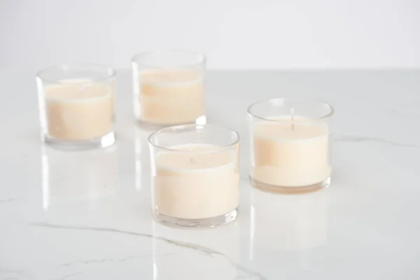 Selective focus of white candles in glass on marble white surface — Stock Photo