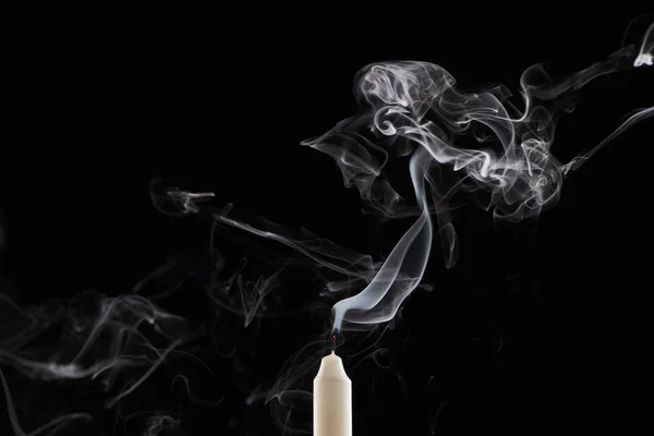 Extinct white candle with smoke on black background — Stock Photo