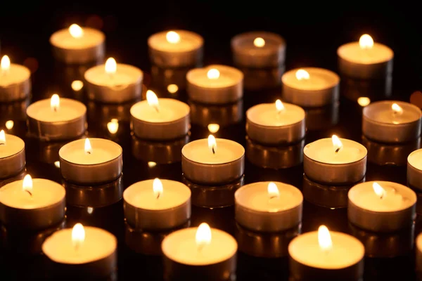 Селективный фокус горящих свечей, светящихся в темноте — стоковое фото