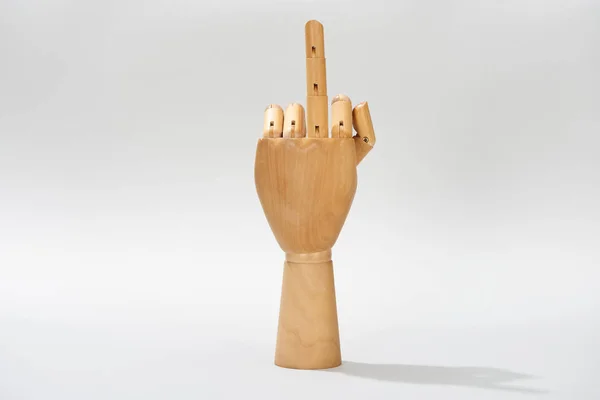 Wooden hand with middle finger gesture on grey background — Stock Photo