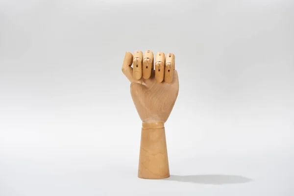 Hand einer Holzpuppe in der Faust auf grauem Hintergrund — Stockfoto