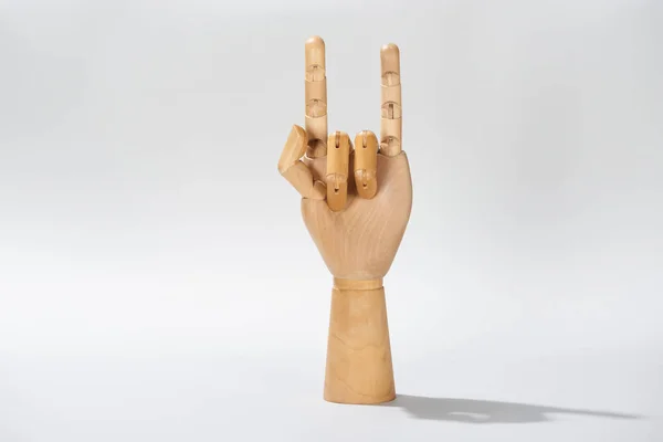 Wooden hand with rock sign on grey background — Stock Photo
