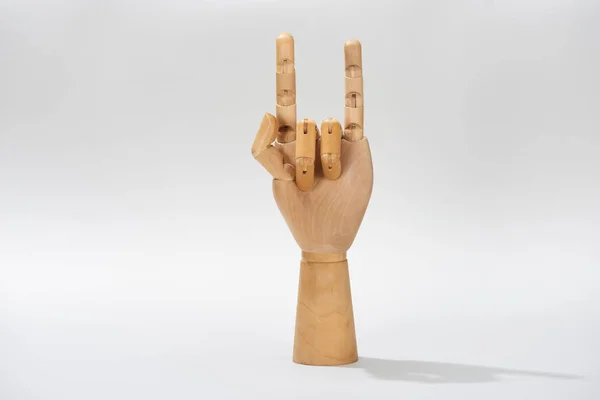 Wooden hand of puppet with rock gesture on grey background — Stock Photo