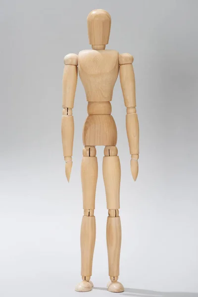 Деревянная кукла с петлями на сером фоне — стоковое фото