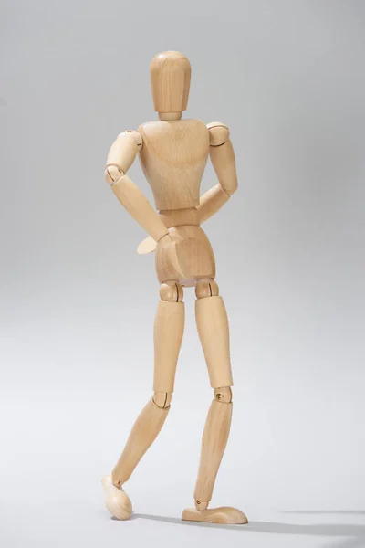 Marionetta in legno con cerniere su fondo grigio — Foto stock