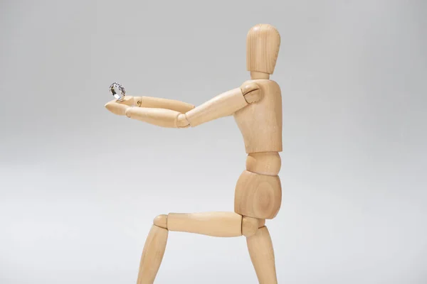 Marionnette en bois avec bague en argent isolée sur gris — Photo de stock