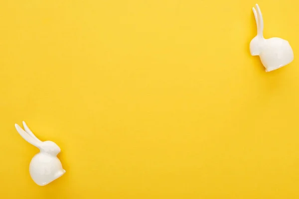 Top view of white Easter bunnies on colorful yellow background — Stock Photo