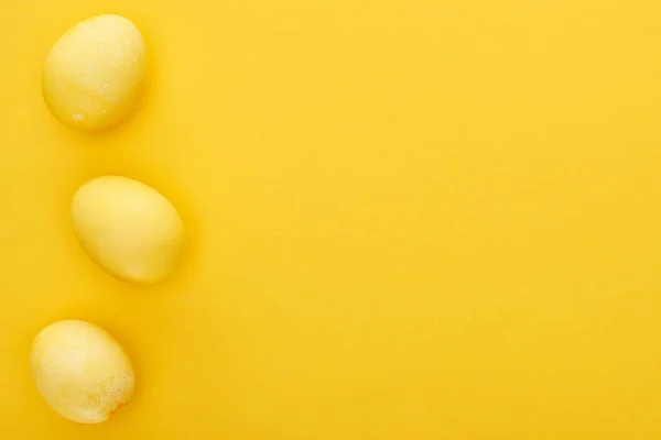 Top view of painted Easter eggs on colorful yellow background — Stock Photo