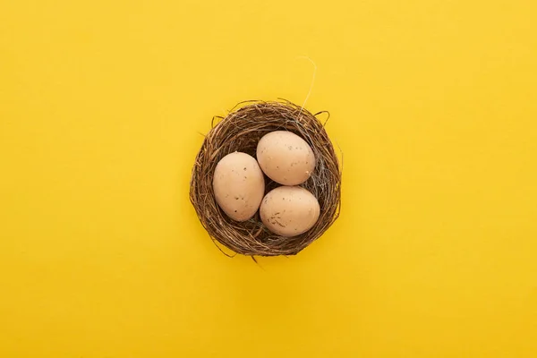 Draufsicht auf Hühnereier im Nest auf buntem gelben Hintergrund — Stockfoto