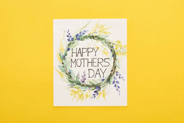 Vista superior de la tarjeta de felicitación feliz día de las madres sobre fondo amarillo colorido - foto de stock