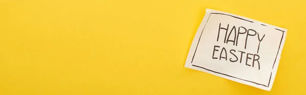 Draufsicht auf Grußkarte mit frohem Osteraufdruck auf gelbem, buntem Hintergrund, Panoramaaufnahme — Stockfoto