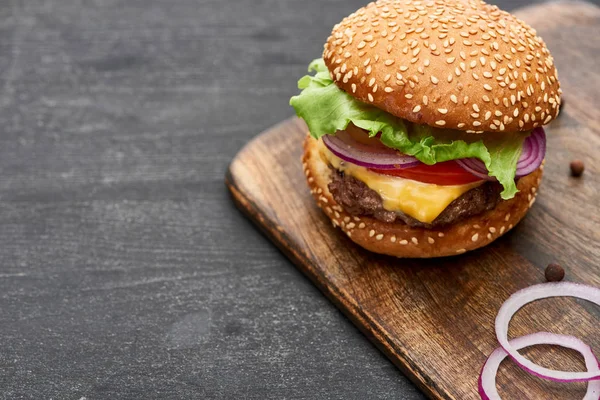 Leckere frische Cheeseburger auf Holzbrett — Stockfoto