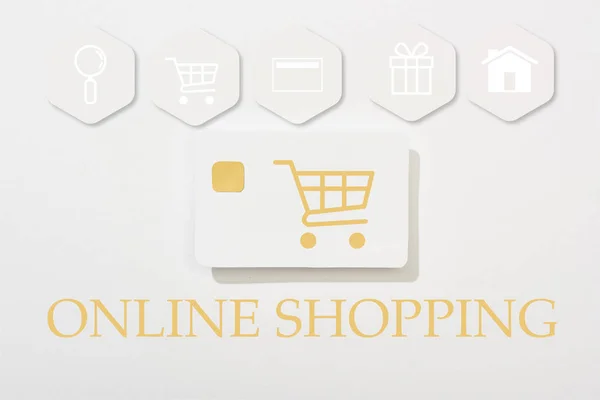Верхний вид кредитной карты на белом фоне с иллюстрацией покупок в Интернете — стоковое фото