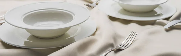 Посуда на волнистой белой скатерти, панорамный снимок — стоковое фото