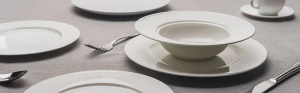 Selective focus of serving tableware with coffee cup on grey tablecloth, panoramic shot — Stock Photo