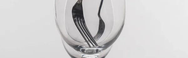 Plan panoramique de fourchettes dans des verres à vin clairs isolés sur gris — Photo de stock