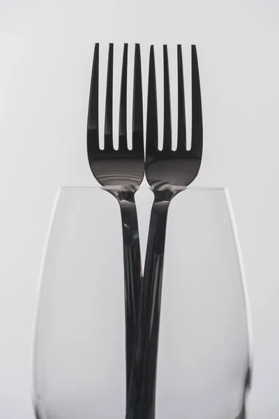 Selective focus of forks in transparent wine glass isolated on grey — Stock Photo