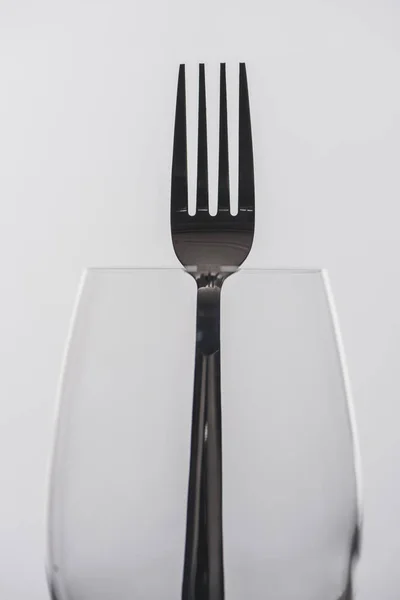 Selective focus of fork in wine glass isolated on grey — Stock Photo